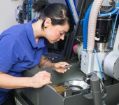 Technician in a dental lab working at a drilling or milling machine